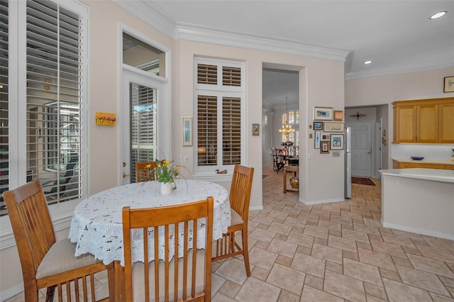 dining room featuring a notable chandelier, recessed lighting, baseboards, and ornamental molding