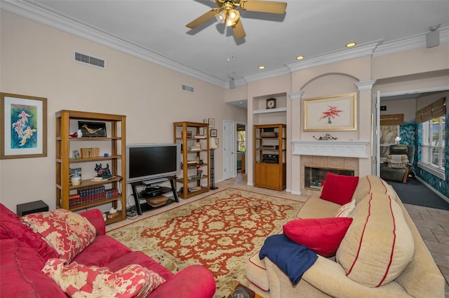 living area featuring visible vents, a tile fireplace, crown molding, and a ceiling fan