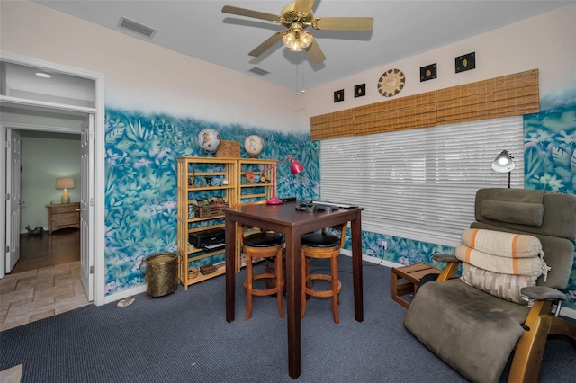 dining room featuring stone finish floor, carpet flooring, visible vents, and ceiling fan