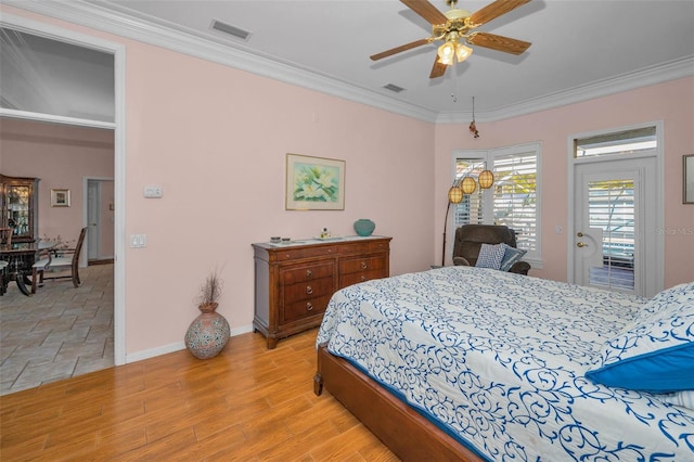 bedroom with visible vents, baseboards, light wood-style floors, and ornamental molding