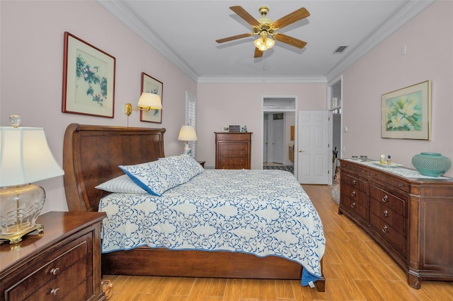 bedroom featuring crown molding, light wood-style floors, visible vents, and ceiling fan