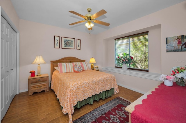 bedroom with ceiling fan, a closet, baseboards, and wood finished floors