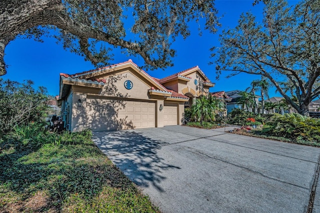 view of front of property featuring a tile roof, concrete driveway, stucco siding, and an attached garage