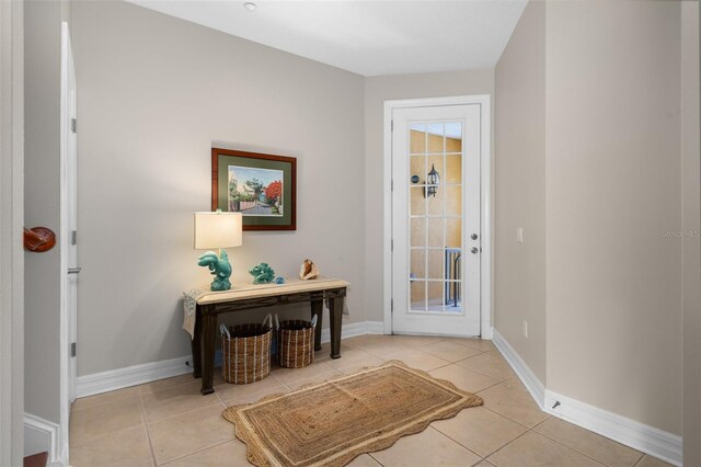 entryway featuring baseboards and light tile patterned floors