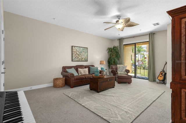 living area featuring visible vents, a ceiling fan, light carpet, a textured ceiling, and baseboards