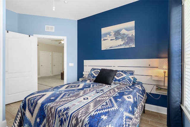 bedroom featuring wood finish floors, visible vents, and baseboards