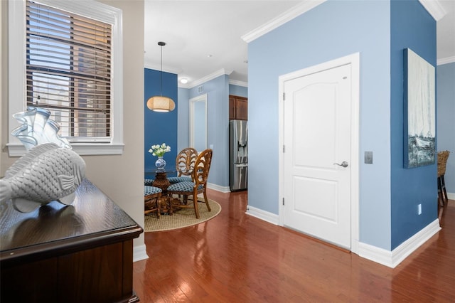 foyer entrance featuring baseboards, ornamental molding, and dark wood-style flooring