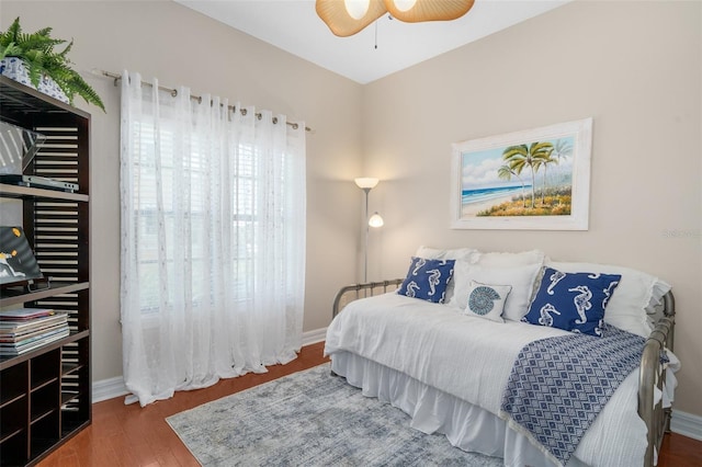 bedroom featuring a ceiling fan, baseboards, and wood finished floors