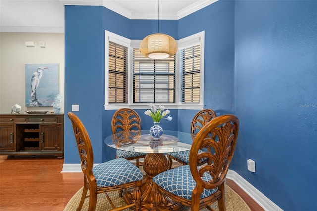 dining room with light wood-style floors, baseboards, and crown molding