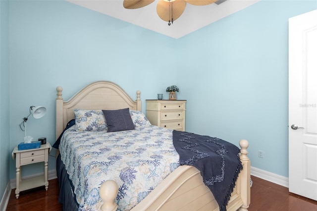 bedroom with a ceiling fan, baseboards, and dark wood-type flooring