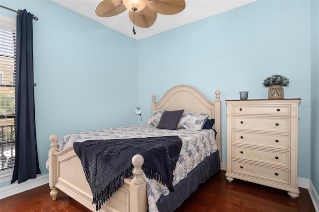 bedroom with dark wood-style floors, multiple windows, and ceiling fan