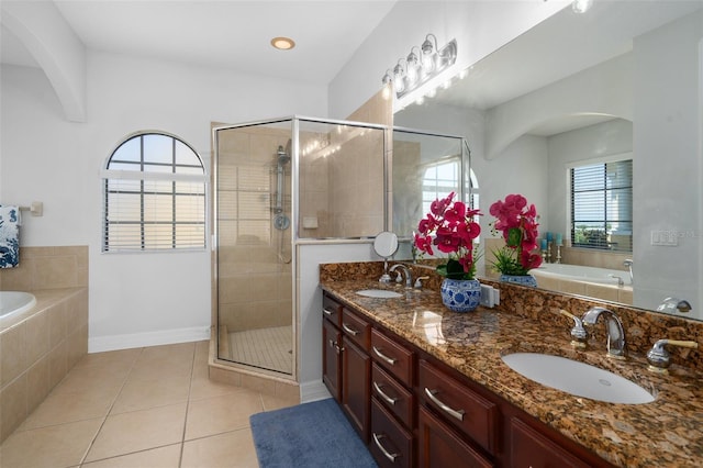 bathroom with plenty of natural light, tile patterned flooring, a garden tub, and a sink