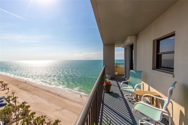 balcony with a water view and a beach view