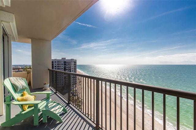 balcony with a water view and a view of the beach