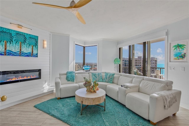 living room featuring a large fireplace, a healthy amount of sunlight, and crown molding