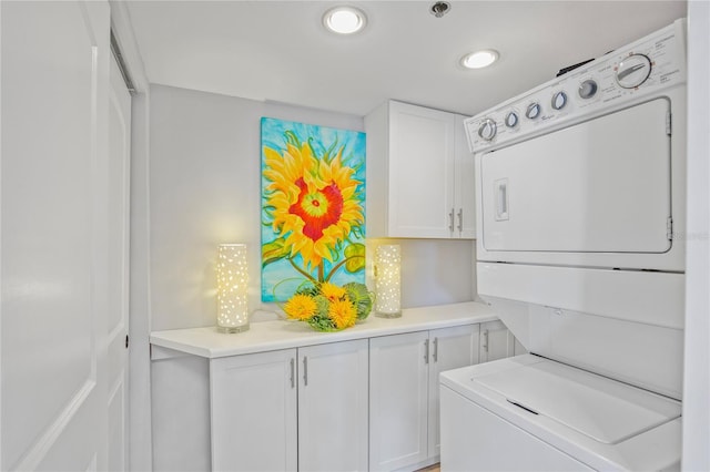 laundry area featuring cabinet space and stacked washer / drying machine