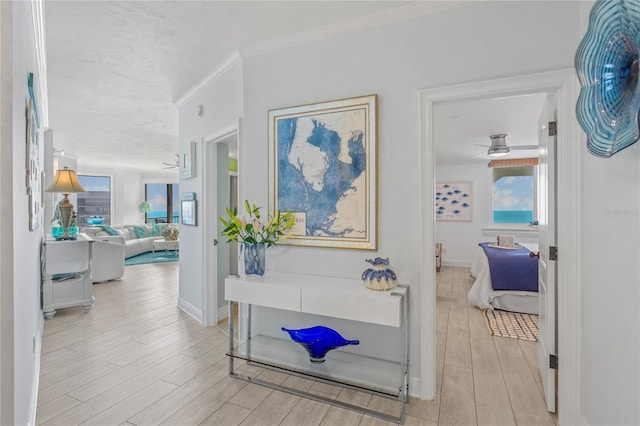 hall featuring wood tiled floor, crown molding, and baseboards