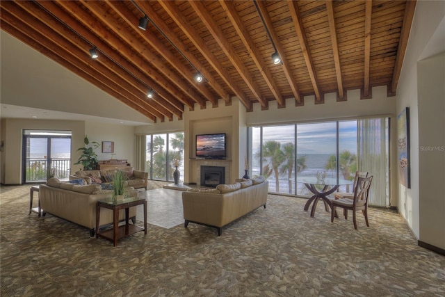 carpeted living area with plenty of natural light, a fireplace, and high vaulted ceiling