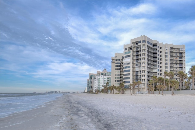 view of building exterior featuring a beach view and a water view