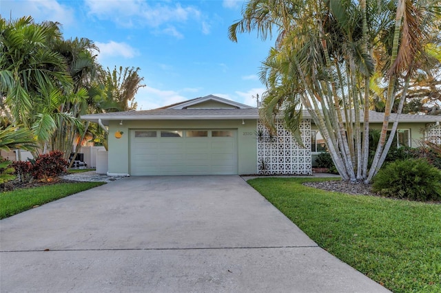 view of front of property featuring driveway, a front lawn, an attached garage, and stucco siding