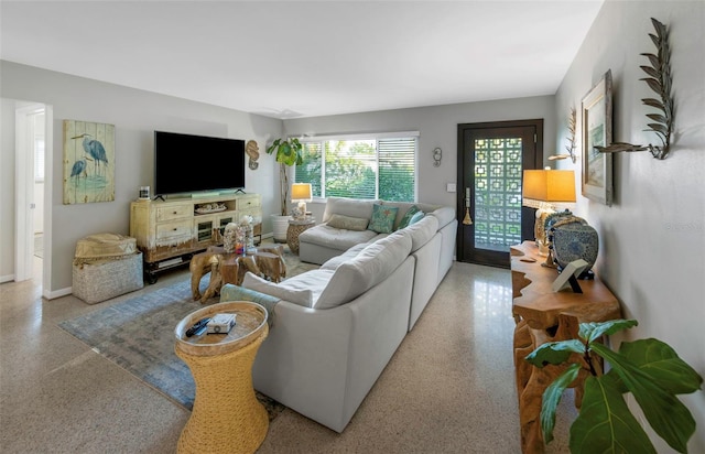 living room featuring light speckled floor and baseboards