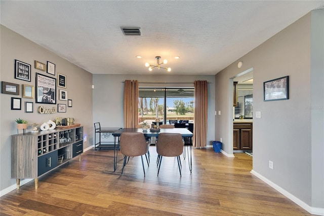 811 Eagle Ln, Apollo Beach, FL 33572 - dining space featuring wood finished floors, a chandelier, and a textured ceiling
