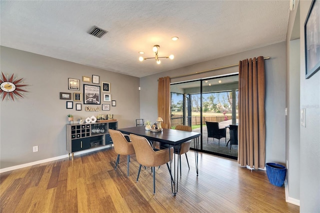 811 Eagle Ln, Apollo Beach, FL 33572 - dining area featuring wood finished floors, a chandelier, a textured ceiling, and a dry bar