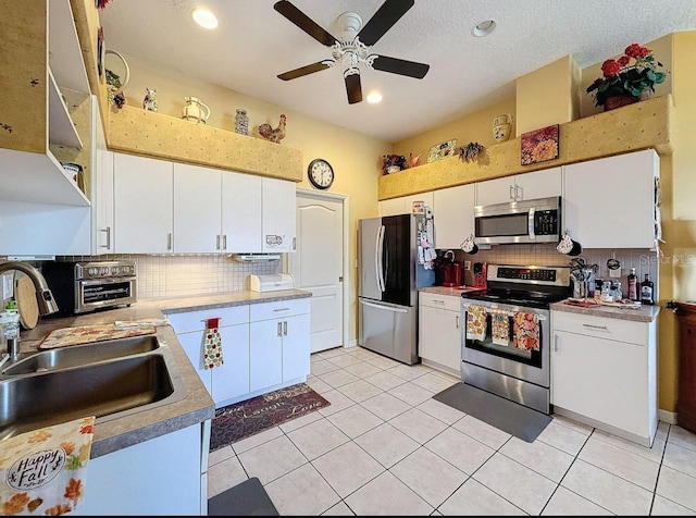 kitchen featuring tasteful backsplash, appliances with stainless steel finishes, and white cabinetry