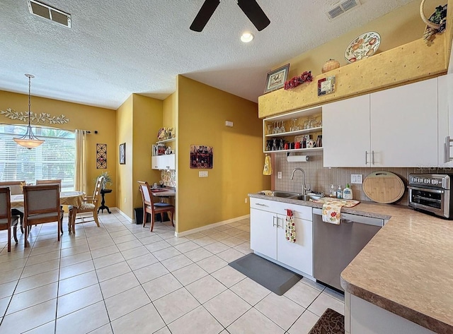 kitchen with visible vents, light tile patterned flooring, a sink, white cabinets, and dishwasher