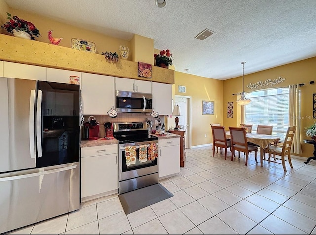 kitchen featuring light tile patterned flooring, visible vents, white cabinetry, and stainless steel appliances