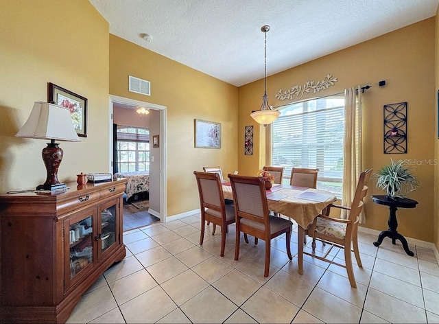 dining room featuring visible vents, baseboards, a textured ceiling, and light tile patterned flooring