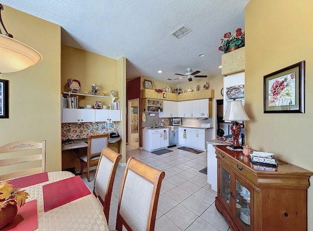 dining area featuring light tile patterned flooring, a ceiling fan, visible vents, and a textured ceiling