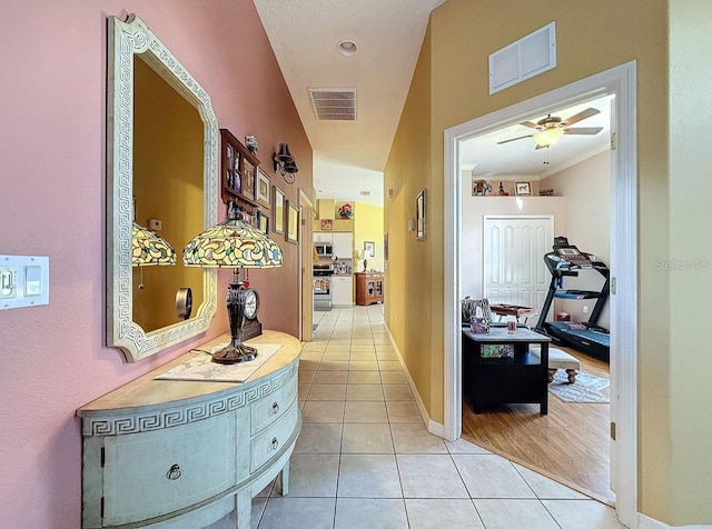 corridor featuring light tile patterned floors, baseboards, and visible vents