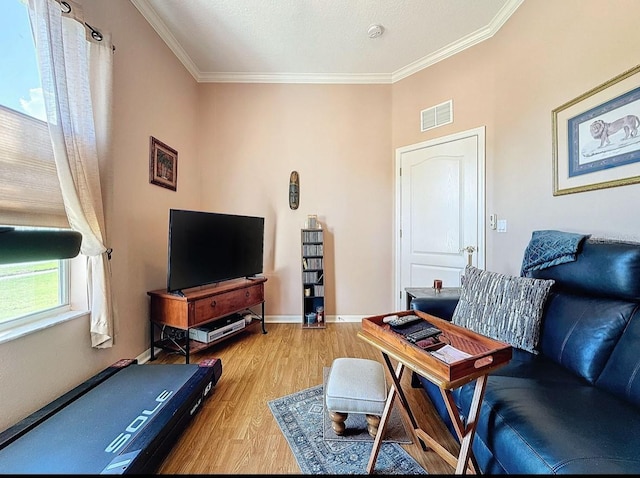 living area with visible vents, light wood-type flooring, baseboards, and ornamental molding