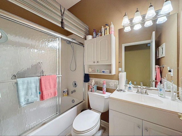 bathroom with vanity, toilet, and combined bath / shower with glass door