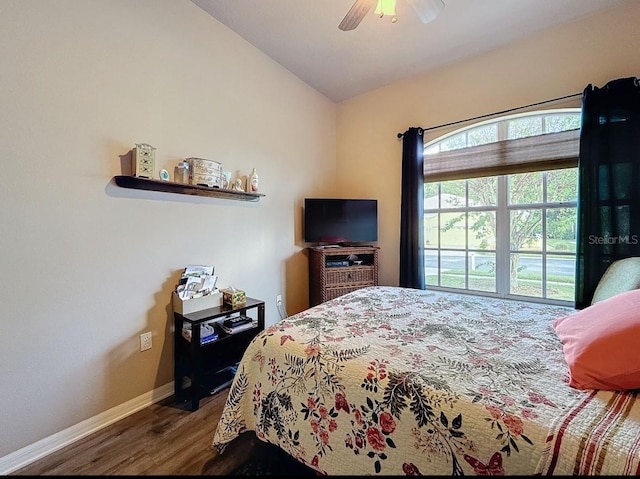 bedroom with ceiling fan, baseboards, lofted ceiling, and wood finished floors