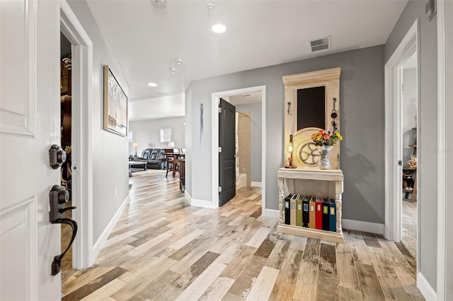 interior space featuring light wood finished floors, baseboards, visible vents, and recessed lighting