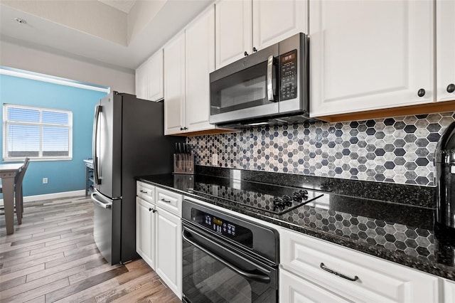 kitchen featuring white cabinets, backsplash, and black appliances