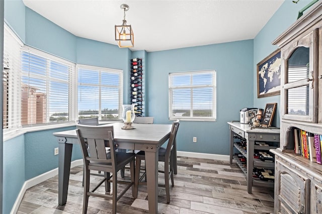 dining space featuring light wood-type flooring, a wealth of natural light, and baseboards