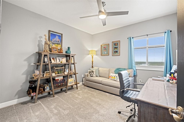 carpeted office space featuring baseboards and a ceiling fan