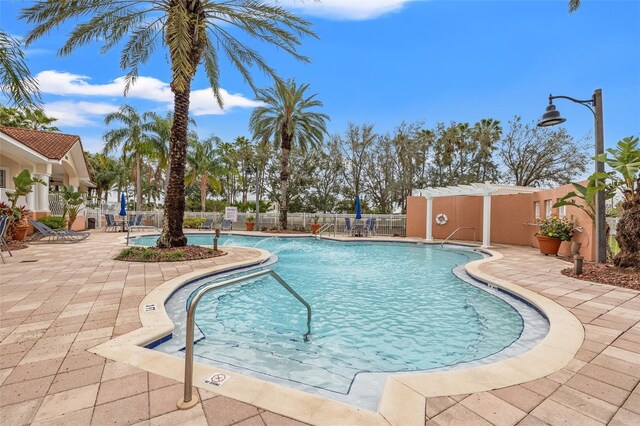 community pool featuring a patio area and fence