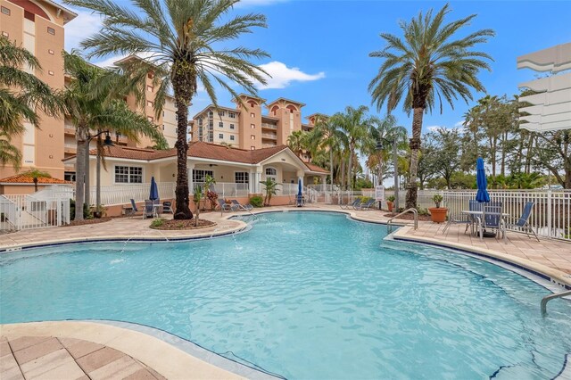 community pool with fence and a patio