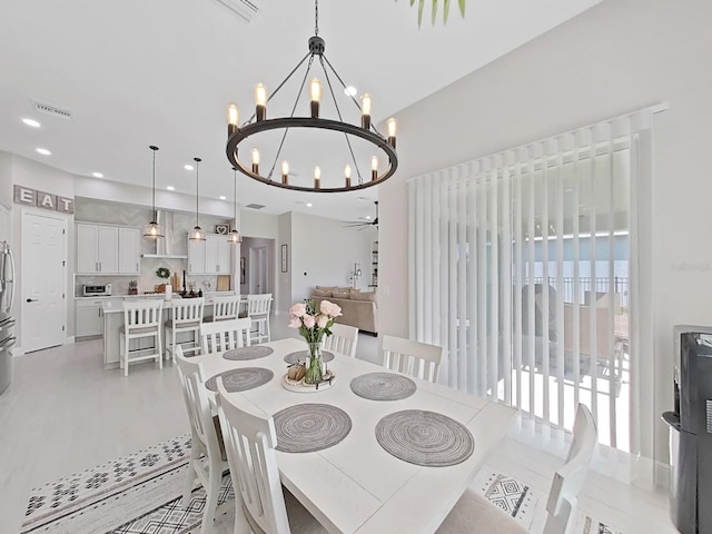 dining space with ceiling fan with notable chandelier, visible vents, and recessed lighting