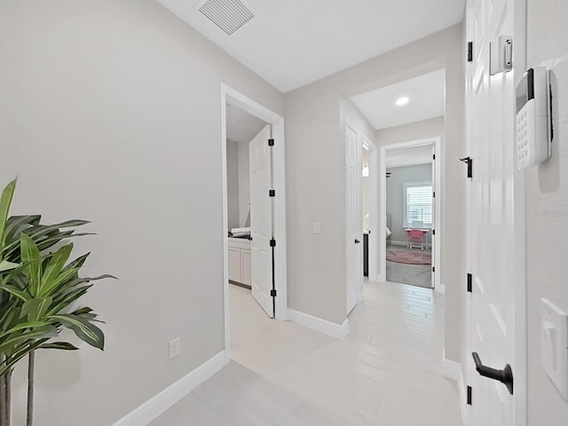 hall with baseboards and visible vents