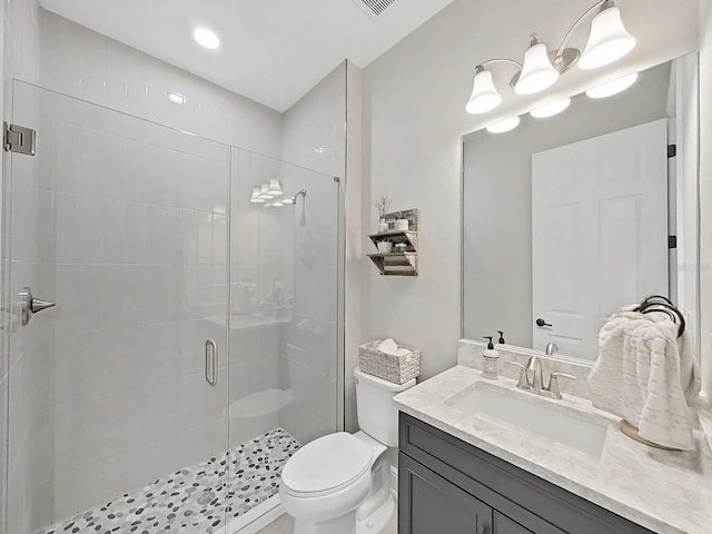 full bathroom featuring a stall shower, vanity, and toilet