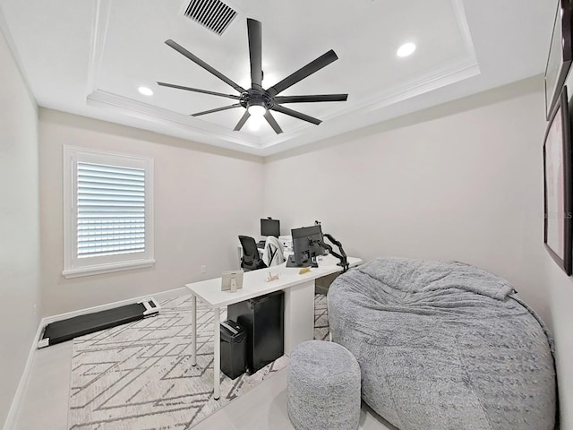 office with visible vents, a raised ceiling, baseboards, ceiling fan, and ornamental molding