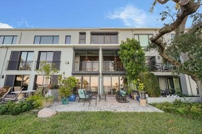 back of house featuring a patio, a yard, and a balcony