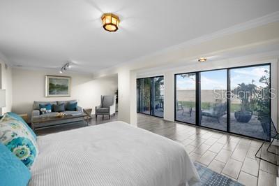 bedroom with crown molding, access to outside, and rail lighting