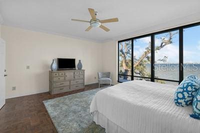 bedroom with multiple windows, ceiling fan, access to outside, and dark parquet flooring