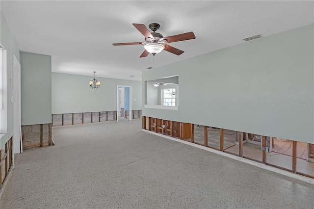 empty room with visible vents and ceiling fan with notable chandelier